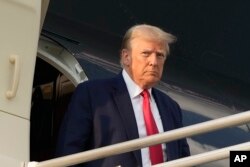 Bivši američki predsednik izlazi iz aviona na aerodromu u Atlanti. (Foto: AP/Alex Brandon)