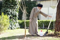 IRAN -- Iranian Supreme Leader Ayatollah Ali Khamenei uses protective gloves as he attends a tree planting ceremony in Tehran, March 3, 2020