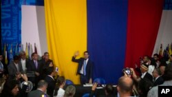 Opposition leader Juan Guaido swears himself in as president of the National Assembly with opposition lawmakers at the newspaper El Nacional's headquarters in Caracas, Venezuela, Jan. 5, 2020.