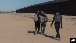 FILE - Nicaraguan migrants walk on the U.S.-Mexico border, in Algodones, Baja California, Mexico, Dec. 2, 2021.