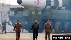 رهبر کره شمالی، کیم جونگ‌اون، در حال دور شدن از آن چه رسانه‌های دولتی یک «نوع جدید» موشک بالستیک قاره‌پیما گزارش کرده‌اند. (آرشیو)