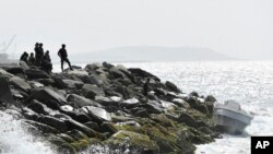 FILE - Venezuelan security forces guard the shore and a boat in the port city of La Guaira, Venezuela, May 3, 2020. 