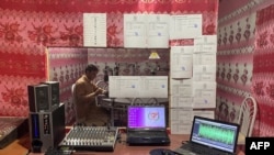 AFGHANISTAN-UNRESTIn this photograph taken on October 12, 2021, radio presenter Ebrahim Parhar reads the news during a broadcast at radio station Urooj in Farah province.