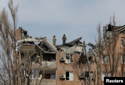 Firefighters work at a residential building damaged by shelling during Ukraine-Russia conflict in the separatist-controlled city of Donetsk, Ukraine March 30, 2022.