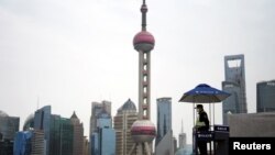 上海因新冠疫情封城。一名保安在陆家嘴金融区的建筑前执勤。（2022年3月28日）