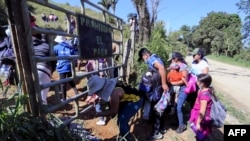 Migran Honduras dan Nikaragua, menyeberang dari Honduras ke Guatemala melalui jalur ilegal, di Corinto, Honduras, pada 15 Januari 2022, sebagai ilustrasi. (Foto: AFP)