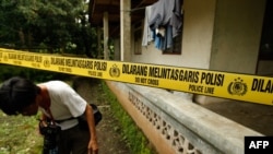 Seorang wartawan melihat-lihat sebuah rumah di Aceh Besar, Provinsi Aceh pada 1 Maret 2010 setelah penggerebekan oleh polisi antiteror untuk mencari tersangka anggota Jemaah Islamiyah. (CHAIDEER MAHYUDDIN / AFP)