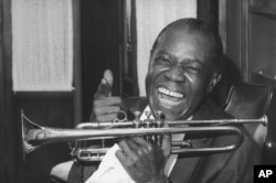 FILE - Jazz trumpeter Louis Armstrong shown in the upstairs den of his Corona, New York home, June 23, 1971.