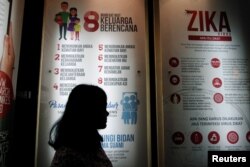FILE - A woman stands near a poster explaining the Zika virus at the Ministry of Health office in Jakarta, Indonesia, Sept. 2, 2016. New WHO chief Tedros Adhanom Ghebreyesus says that among his priorities will be to strengthen the WHO's ability to respond swiftly and effectively to health emergencies.