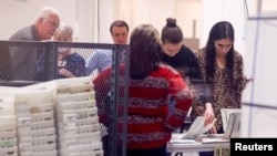 Staff work as they scan ballots for the U.S. midterm elections at the Maricopa County Tabulation and Election Center in Phoenix, Ariz., Nov. 11, 2022.