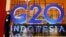 一名保安站在二十国联合峰会峰的巨大招牌旁，二十国卫生和财政部长即将在印尼巴厘岛参加这次峰会有关健康、可持续能源及数码转变加的讨论，然而俄乌冲突、美中与西方国家日益紧张的关系或将始终是这次会议挥之不去的阴影。