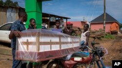 Watu wakiweka jeneza kwenye piki piki kwa ajili ya kusafirishwa kwa mazishi ya mtu aliyefariki dunia kutokana na maambukizi ya virusi vya Ebola katika wilaya ya Kassanda, Uganda. Nov 1, 2022
