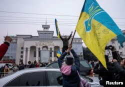 Local residents celebrate after Russia's retreat from Kherson, in central Kherson, Ukraine, Nov. 12, 2022.