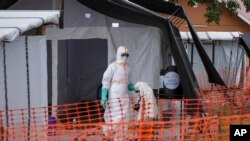 Medical workers walk inside the Ebola isolation center of Madudu Health Center III in the Mubende district of Uganda, Nov. 1, 2022. The country has recorded 137 Ebola cases and 54 deaths since the outbreak began in September.
