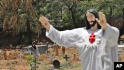 A worker prepares the grave for a COVID-19 victim at a Christian cemetery in New Delhi, India, May 21, 2021.