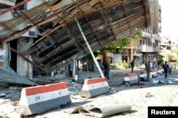 FILE - Syrian army soldiers stand at a site of an explosion in Bab Tadmor in Homs, Syria in this handout picture provided by SANA, September 5, 2016.