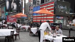 Servers package food at a table at a pop up restaurant set up in Times Square for 'Taste of Times Square Week' during the coronavirus disease (COVID-19) pandemic in the Manhattan borough of New York City, New York, U.S., October 23, 2020. REUTERS/Carlo Al