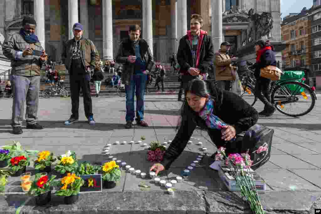Warga menaruh lilin berbentuk hati untuk menghormati para korban ledakan tiga bom, di depan gedung bursa saham di pusat kota Brussels (22/3).&nbsp;(AP/Geert Vanden Wijngaert)