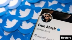 FILE: Elon Musk's Twitter profile is seen on a smartphone placed on printed Twitter logos in this picture illustration taken April 28, 2022.
