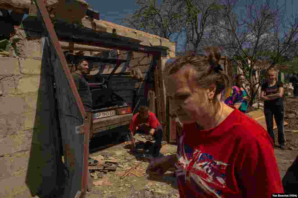 Zaporijyada raket düşəndən sonra ailə təmizlik işləri aparılır. Hücumda 3 nəfər yaralanıb