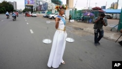 Cambodian-American lawyer Theary Seng, dressed in a pageant costume that reads "Lady Justice", walks outside Phnom Penh Municipal Court in Phnom Penh, Cambodia, Tuesday, May 3, 2022. Tuesday is the the final day of hearings for her trial on treason and a related charge for which she could receive a prison sentence of up to 12 years. (AP Photo/Heng Sinith)