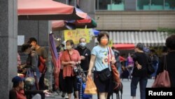 Warga mengenakan masker untuk mencegah infeksi virus corona di sebuah pasar di Keelung, Taiwan, 28 April 2022. Foto: Reuters