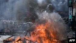 A picture shows burning pallets in the street during clashes between protesters and police on the sidelines of the annual May Day (Labor Day) rally, marking International Workers' Day, in Paris on May 1, 2022. 