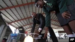 Wani malami, Lawal Olaide da dalibarsa Adebola Duro-Aina da ta hada janareto mai samar da wutar lantarki ta hanyar amfani da fitsari a Legas (Hoto: AP)