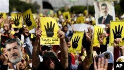 Protesters hold placards with the symbol of Rabaah al-Adawiya mosque, where supporters of Egypt's ousted President Morsi held a sit-in that was violently dispersed, Cairo, Sept. 13, 2013.