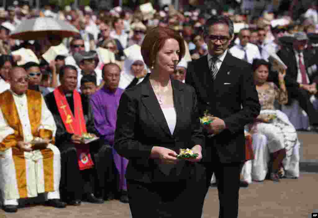 Australian Prime Minister Julia Gillard, left, walks with Indonesia Foreign Minister Marty Natalegawa as they offer flowers during a Bali bombings memorial service, Bali, Indonesia, October 12, 2012.