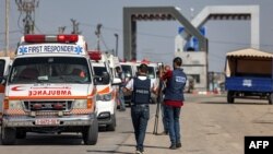 1일 가자지구에서 라파 국경통제소에 들어서는 구급차들을 취재진이 촬영하고 있다. 