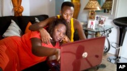 FILE - Yaisah Val, 46, a transgender woman, watches a movie with her husband, Richecarde Val, 28, in their home in Port-au-Prince, Haiti, on July 14, 2018. 