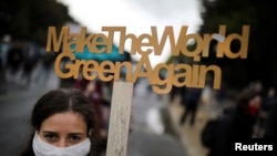 A demonstrator holds a sign as Fridays for Future activists protest calling for a "Global Day of Climate Action" in Berlin, Germany, Sept. 25, 2020. 