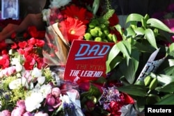 A father's day card sits amongst flowers left for the victims of the Grenfell apartment tower fire in North Kensington, London, Britain, June 18, 2017.