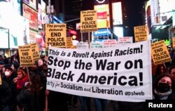 Orang-orang membawa spanduk selama aksi protes pada hari perilisan video yang memperlihatkan polisi Memphis memukuli Tyre Nichols, dalam aksi di kota New York, 27 Januari 2023.