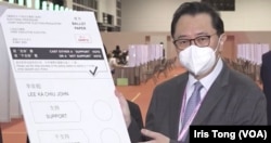 香港选举管理委员会主席冯骅向传媒展示5月8日特首选举的模拟选票。 (美国之音 汤惠芸)