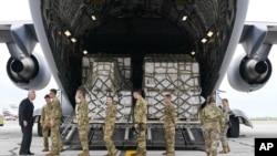 톰 빌색(왼쪽) 미 농무부 장관이 22일 인디애나폴리스 국제공항에서 유럽산 분유를 실은 C-17 수송기와 관계 병력을 맞고 있다.
