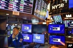 A trader works on the floor at the New York Stock Exchange in New York, Thursday, May 19, 2022. Stocks are opening moderately lower in early trading on Wall Street, finding some stability a day after their biggest drop in nearly two years. (AP Photo/Seth