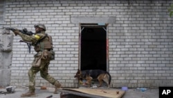 A Ukrainian serviceman patrols during a reconnaissance mission in a recently retaken village on the outskirts of Kharkiv, east Ukraine, May 14, 2022.