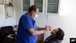FILE - A doctor examines a patient in his office in the Iztapalapa neighborhood of Mexico City, Feb. 6, 2021. 