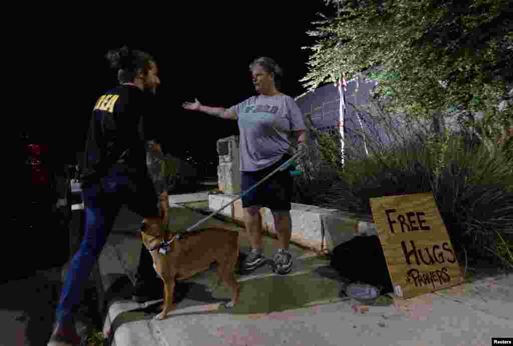 Jennifer Click offers hugs to people coming and going at the Ssgt. Willie de Leon Civic Center after a mass shooting at Robb Elementary School in Uvalde, Texas, May 24, 2022.