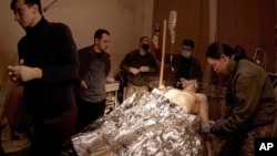 Yuliia Paievska, known as Taira, watches as emergency personnel try to save the life of a man on March 2, 2022, in Mariupol, Ukraine.