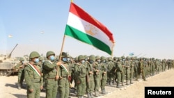 FILE - Service members of Tajikistan's armed forces line up during the joint military drills involving Russia, Uzbekistan and Tajikistan, at Harb-Maidon training ground, located near the Tajik-Afghan border, Aug. 10, 2021.