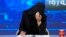 FILE - TV anchor Khatereh Ahmadi bows her head while wearing a face covering as she reads the news on TOLO NEWS, in Kabul, Afghanistan, May 22, 2022, after Taliban rulers required all female TV news anchors in the country to cover their faces while on-air. 
