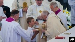 Pope Francis gives Holy Communion during the canonization Mass for 10 new saints in St. Peter's Square at The Vatican, Sunday, May 15, 2022. 