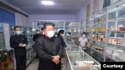 Pemimpin Korea Utara Kim Jong Un mengenakan masker ketika berkunjung ke salah satu apotek di Pyongyang, dalam foto yang dirilis oleh Kantor Berita Korea Utara pada 15 Mei 2022. (Foto: KCNA via Reuters)
