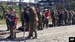 우크라이나 남동부 항구도시 마리우폴 시내 아조우스탈 제철소에서 나온 투항병들이 18일 러시아군 통제 지역으로 가기 위해 대기하고 있다. (러시아 국방부 제공)