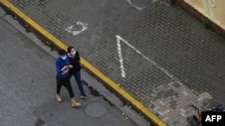 FILE - People walk on a street during a Covid-19 coronavirus lockdown in the Jing'an district, in Shanghai on May 21, 2022. 