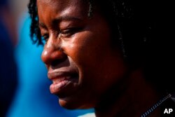 A person is overcome with emotions outside the scene of a shooting at a supermarket, in Buffalo, N.Y., May 15, 2022.
