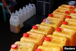 Seorang petugas mengisi jerigen dengan minyak goreng di sebuah stasiun distribusi di Jakarta, 20 Mei 2022. (REUTERS/Willy Kurniawan)